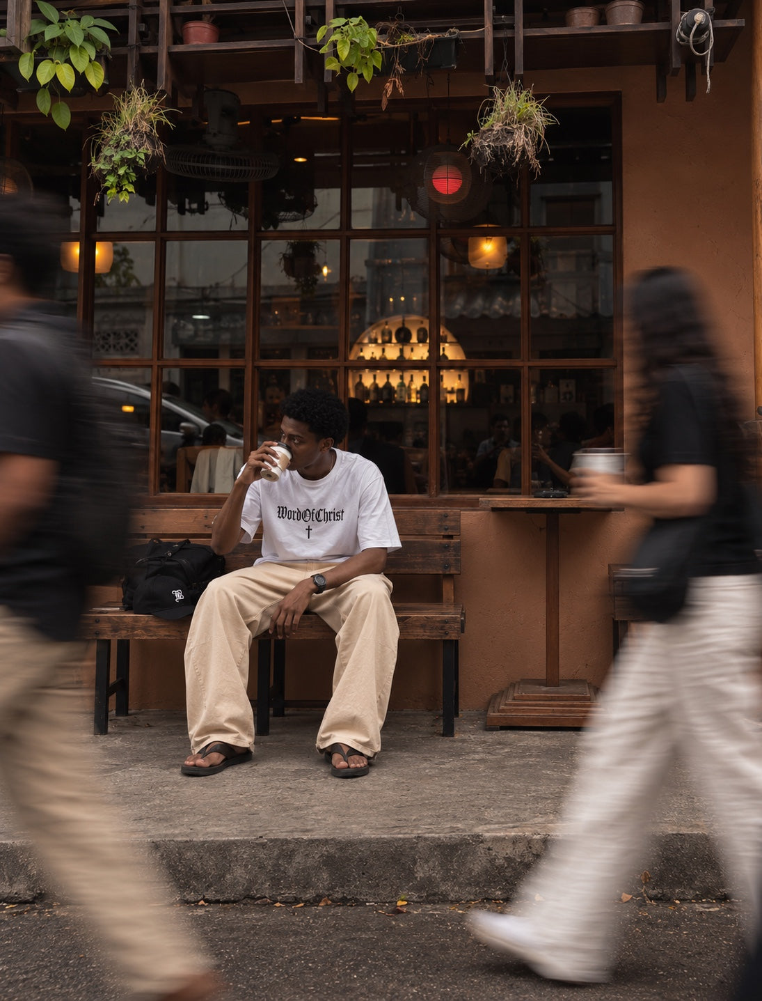 Model wearing a white WordOfChrist tee outside a cafe